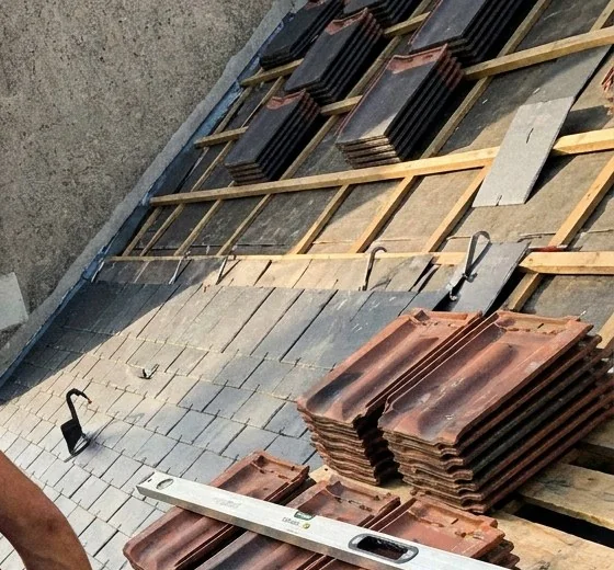 Liteaux neufs et matériaux répartis sur un pan de toiture en ardoise pendant une réfection à Nantes